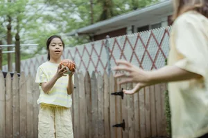 A child throwing a basketball towards a coach
