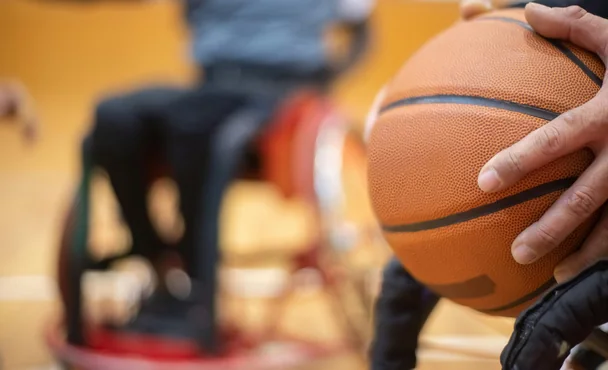 Young people playing basketball in a sports hall